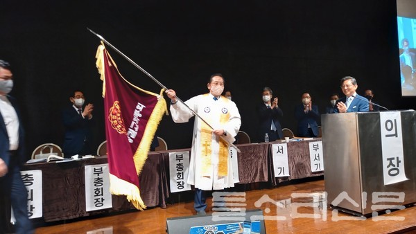 신임총회장 신현파 목사가 교단기 휘장을 받아들고 있다.